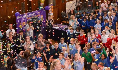 Lots of children in a hall at a school science fair