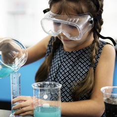 Child in safety glasses doing a science experiment 