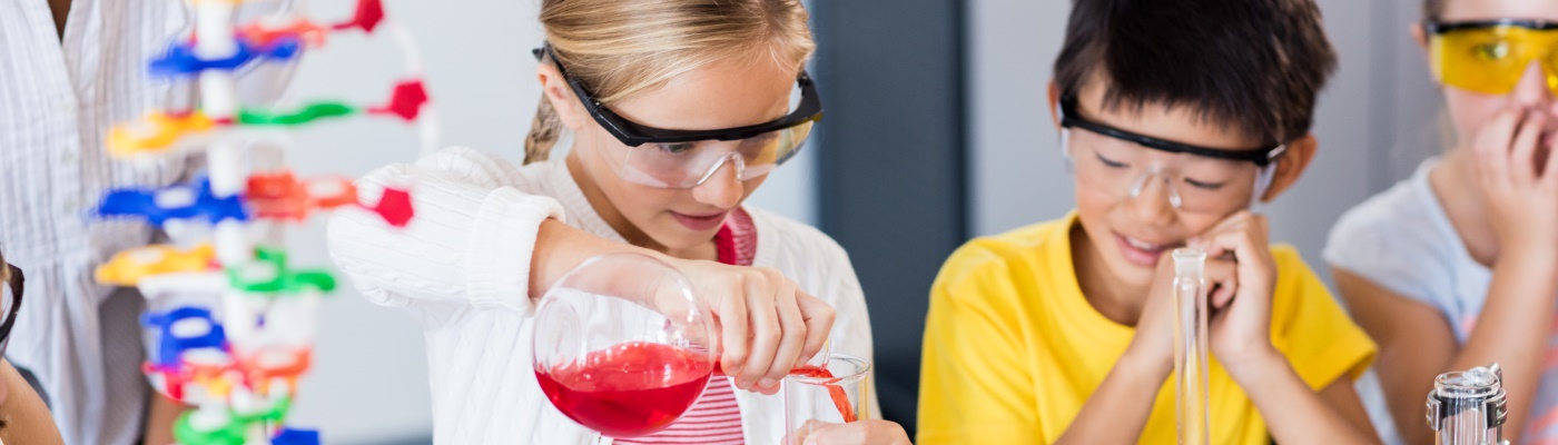 Children in safety glasses conducting science experiments 