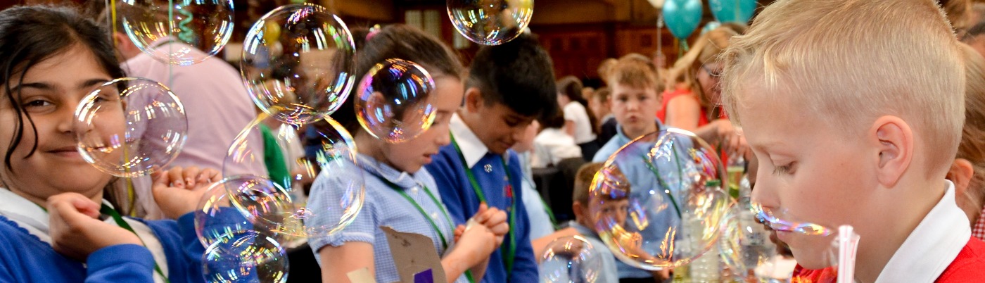 Group of children blowing bubbles at a science event 
